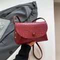 Bolso bandolera burdeos con textura trenzada, hebilla redonda y remaches dorados - Rojo