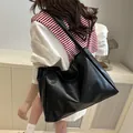 Grand sac cabas noir en similicuir porté par le modèle pour un look quotidien chic - Noir (Sans Pendentif)