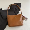Brown faux leather shoulder bag with silver bow accent and plush bear charm detail - With Pendant / Brown