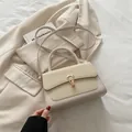 Bolso bandolera beige con solapa tejida y cierre de herradura dorado sobre tela - Blanco Roto