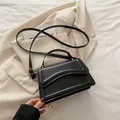 Fashionable black leather handbag with pleated flap design and golden hardware - Black