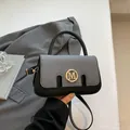 Chic black and grey mixed-media handbag with gold M logo and adjustable shoulder strap - Black