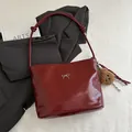 Glossy burgundy leather tote bag with silver bow accent and plush charm detail - With Pendant / Red