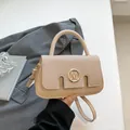 Beige faux leather handbag with metal M logo and top handle in a lifestyle setting - Off White