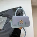 Light blue patchwork handbag featuring denim texture and a golden M-logo circular clasp - Blue