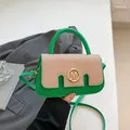 Chic green leather and beige canvas handbag with golden M buckle and crossbody strap - Green