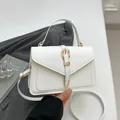 Bolso bandolera minimalista de cuero blanco con elegantes herrajes dorados y asa superior - Blanco