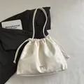Chic cream white drawstring bucket bag with bow detail and soft faux leather texture - White
