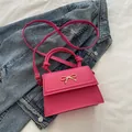 Bolso bandolera fucsia con decoración de lazo metálico dorado y asas anudadas - Rosa intenso