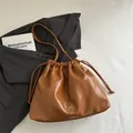 Caramel drawstring bucket bag with silver bow accent on soft leather shoulder strap - Brown