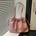 Pink drawstring bucket bag in soft PU leather with a decorative silver bow charm - Pink