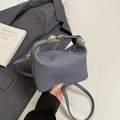 Bolso almohada azul grisáceo con textura, herrajes dorados y correa larga de hombro - Azul