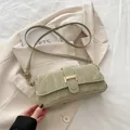 Bolso baguette verde claro con textura de mármol y hebilla dorada sobre blazer - Verde