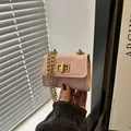 Mini borsa a tracolla rosa con catena dorata e chiusura a girello mostrata in mano - Rosa
