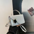 Petit sac carré argenté avec rabat pailleté et boucle métallique porté à la main - Argent