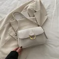 Elegant off-white crossbody bag with crocodile texture and gold hardware horseshoe buckle - White