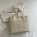 Cream tote bag with repeating M pattern and center FASHION logo on stylish background - Khaki