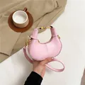 Rosa sichelförmige Tasche aus Kunstleder mit goldenen Details und schmalem Gurt - Rosa