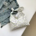 Stylish tote bag with purple floral print and knotted strap design on a clean background - Beige