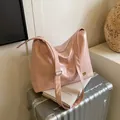 Chic light pink glossy patent leather tote bag with gold logo on silver suitcase - Pink