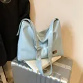 Light blue glossy leather tote bag with silver logo and adjustable wide strap - Blue
