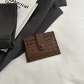 Dark brown woven leather card holder with multiple slots and a secure snap button closure - Brown