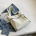 White corduroy tote bag for women featuring a stylish black zipper and minimalist shoulder straps - White