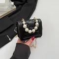 Black heart quilted mini bag with elegant faux pearl handle and gold chain strap - Black