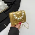 Golden heart-quilted crossbody bag with pearl handle and metal chain strap - Gold