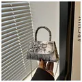 Close-up of snakeskin pattern leather mini bag with silver bow accent and chain strap - White