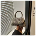 Detail of snake print mini handbag with silver bow ornament and elegant chain strap - Khaki