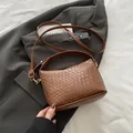 Bolso de mano marrón con textura trenzada y correa ajustable con herrajes dorados - Marrón
