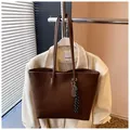 Détail d'un sac cabas en cuir marron avec pendentif raquette et foulard à carreaux - Avec Pendentif / Café