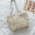 Bolso tote de paja beige con bordado floral verde y detalle de lazo de encaje - Blanco Roto
