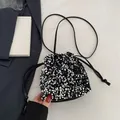 Chic black and silver sequin drawstring bucket bag with a thin shoulder strap design - Silver