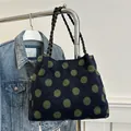 Navy knit tote bag with bold green polka dots and woven black shoulder strap - Green