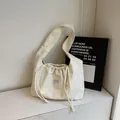 Minimalistische beige Schultertasche aus Cord mit Kordelzug und stilvollem Textilaufnäher - Gebrochenes Weiß