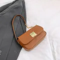 Elegante bruine leren crossbodytas met gouden gesp en een grove metalen kettingriem - Bruin