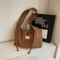 Braune Schultertasche aus Cord mit Kordelzug, minimalistischer Textur und weißem Etikett - Khaki