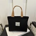 Mini schwarze Canvas Tasche mit braunen Griffen und minimalistischem Bären Patch - Schwarz