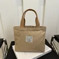 Mini beige Segeltuchtasche mit Bären-Patch und braunen Griffen für den Alltag - Khaki