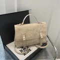 Zaino vintage beige con patta e fibbie dorate su display minimalista elegante - Kaki