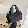 Bolso de mano cilíndrico de nailon negro minimalista con correa ajustable para hombro - Negro