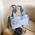 Bolso de mano cilíndrico minimalista en nailon azul claro con correa de hombro ajustable - Azul