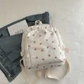 Mini cream floral backpack with pink tulip pattern and zip front pocket on a white fabric - White
