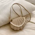 Bolso de noche con forma de concha color oro champán con asa de perlas y textura metal - Dorado