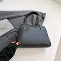 Minimalist black large capacity shoulder bag in matte faux leather with front pocket - Black