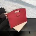 Red lychee grain leather handbag featuring minimalist hollow handle and flap closure - Red