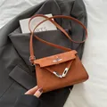 Braune Mini-Umhängetasche aus Wildleder mit Metall-Drehverschluss und Gurt - Braun