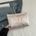 Bolso de mano en satén rosa pálido con bordado de mariposa y acabado sedoso - Rosa